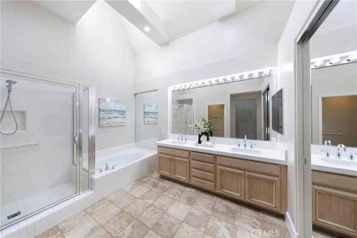 Primary ensuite basked in natural light and high ceilings, with His & Hers vanity, stand alone shower, separate tub,  and walk-in closet.