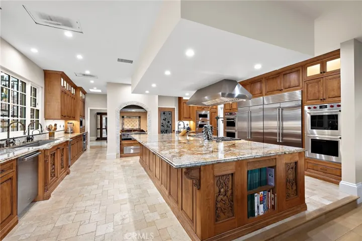 Luxury Kitchen Featuring Wolf Stainless Steel Appliances and Hand Carved Wood