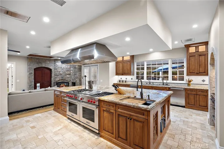 Luxury Kitchen Featuring Wolf Stainless Steel Appliances and Hand Carved Wood