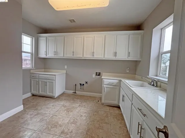 Laundry room with hookup for a washing machine, gas dryer hookup, cabinet space, and hookup for an electric dryer