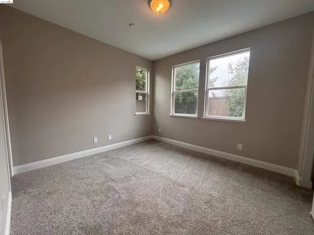 Spare room with light colored carpet and baseboards