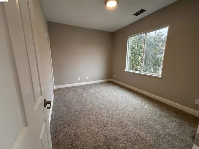 Unfurnished room with light colored carpet and baseboards