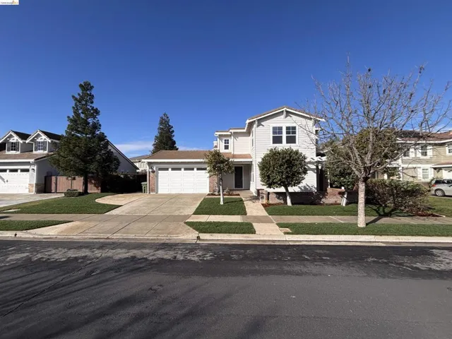 Traditional-style home featuring concrete driveway, an attached garage, brick siding, a porch, and a residential view