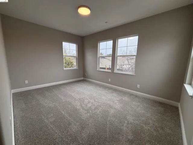 Unfurnished room featuring light colored carpet and baseboards