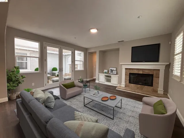 Living room with dark wood-style flooring, a tile fireplace, and french doors