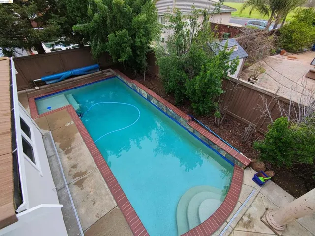 View of pool featuring a fenced backyard and patio surround
