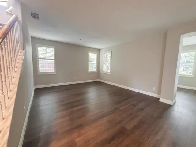 Unfurnished room with dark wood-type flooring