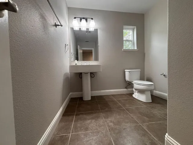 Bathroom with a textured wall and tile patterned floors