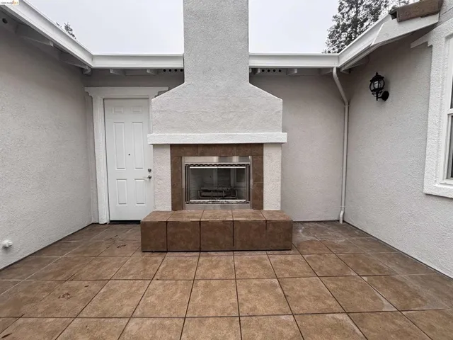 View of patio with a tile fireplace