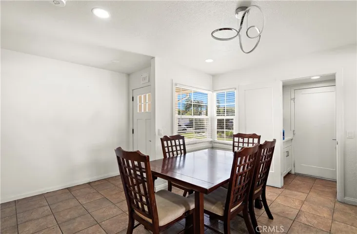 Entry Door and Foyer Opens to Dining Room, Kitchen, and Living Room all with Tile Flooring and Recessed Lighting. Doorway on Right Leads to Staircase to 2nd Floor