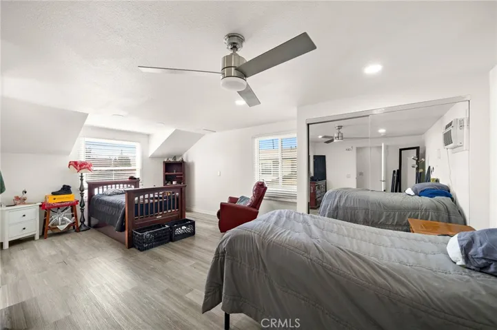 expansive upstairs primary suite offers wood laminate flooring, two mirrored closets