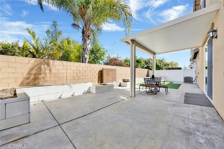 Spacious backyard with partial patio cover, build-in planters, and feng shui water element feature