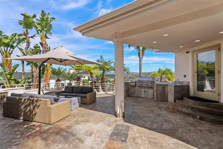 Outdoor kitchen space is cover, just off the kitchen for convience and again those amazing views.  The gate on the side of the fireplace leads down to the lower level patio and bedrooms.