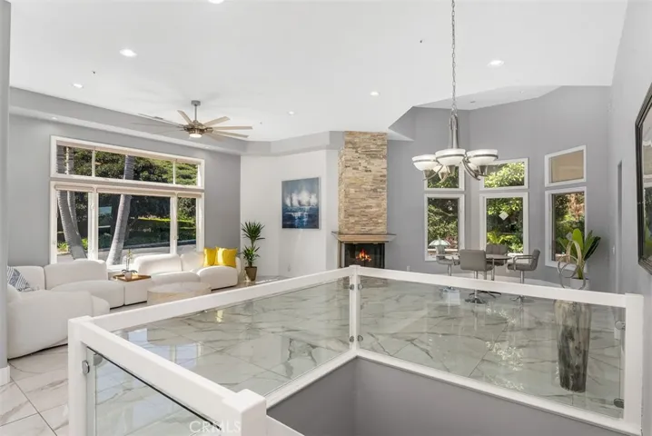 Formal living room and dining room with shared fireplace, just off the kitchen.  Dining area overlooks the side yard and fountain.