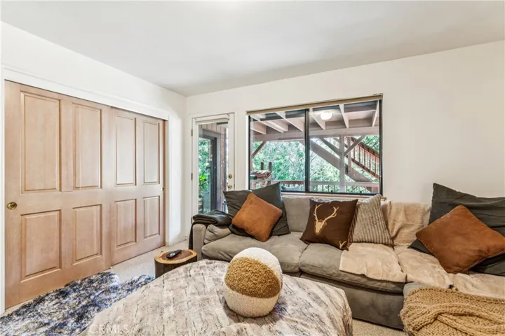 Media room/bedroom with wall of closets and outside deck access