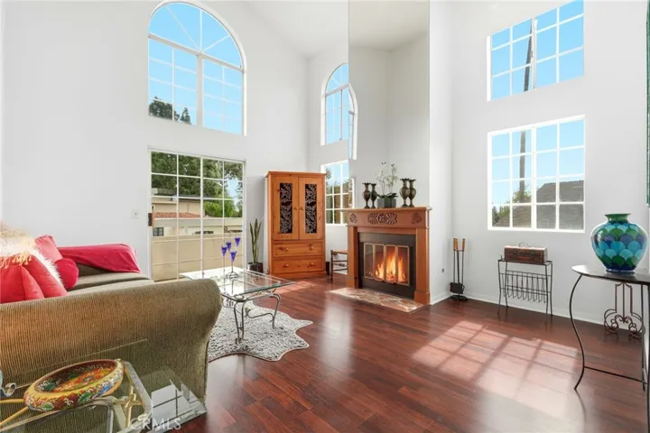 Living room filled with natural light which pours in from floor to ceiling windows
