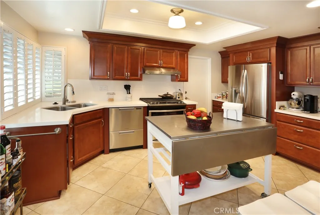 Quartz counters, plantation shutters, tile flooring and beautiful cabinets complete the kitchen.