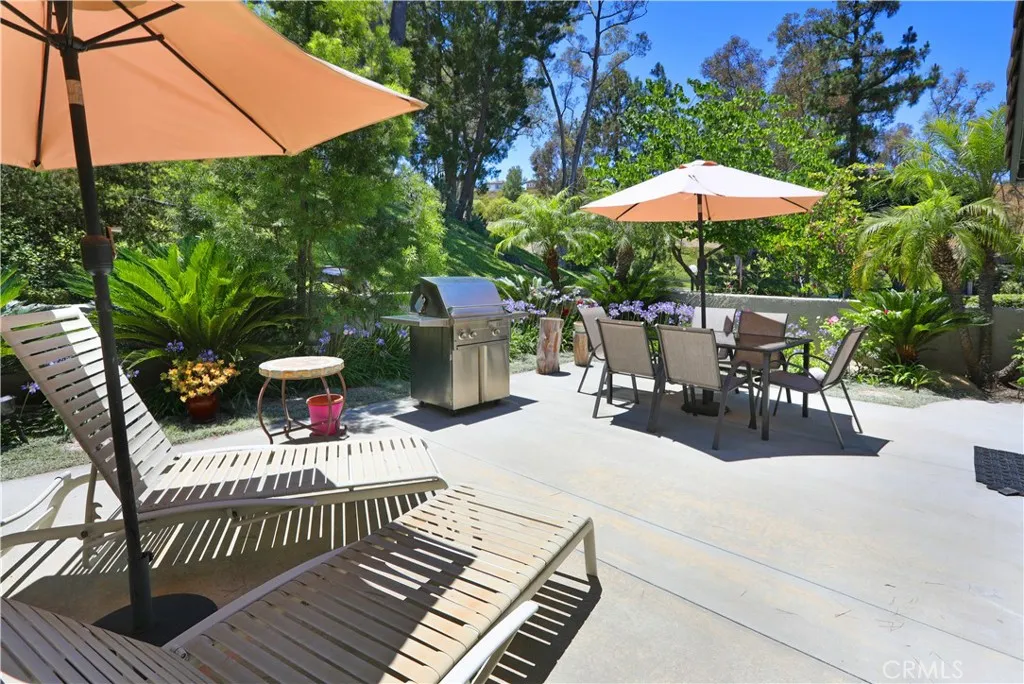 Beautiful green hillside and landscaping surround this lush patio.