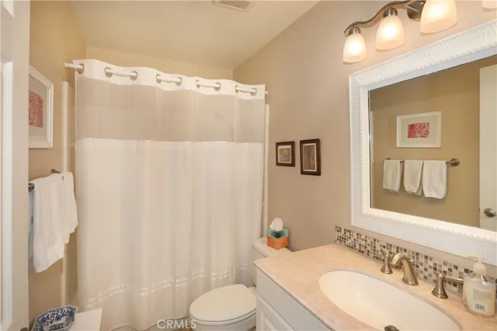 This guest bathroom has a shower over tub and tile flooring.
