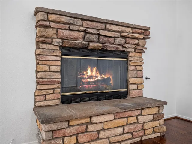 Spacious living room with cozy fireplace and laminate flooring, creating a warm and inviting gathering space.