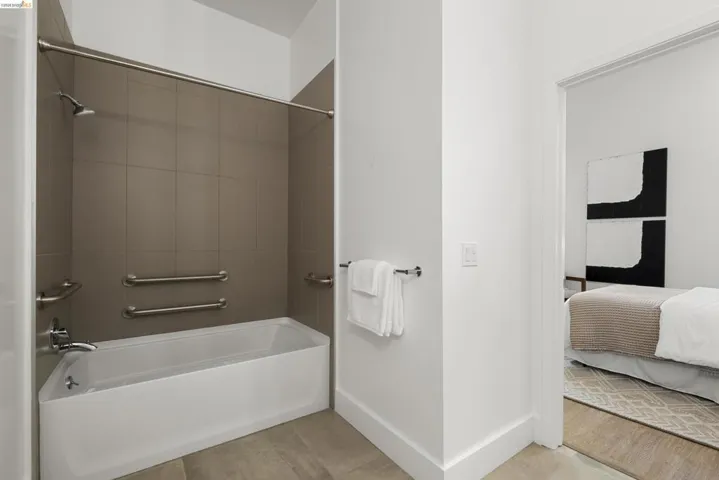 Ensuite bathroom featuring bathtub / shower combination and light tile patterned flooring