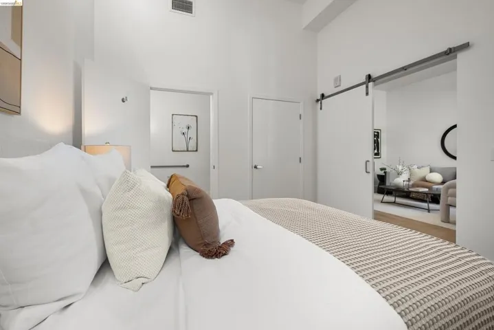 Bedroom with a barn door and wood finished floors
