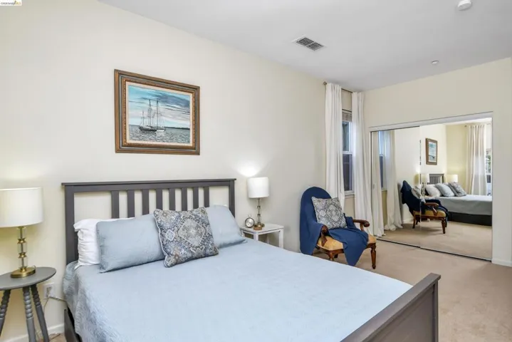 Bedroom with light colored carpet and a closet