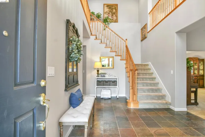 Foyer entrance featuring stone tile floors and a high ceiling