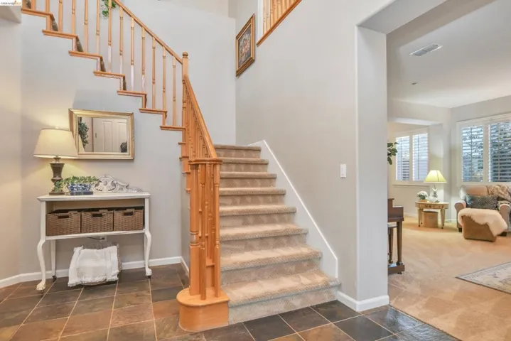 Stairs with stone tile flooring and carpet flooring