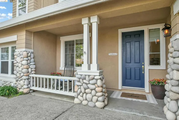 View of exterior entry with covered porch and stucco siding