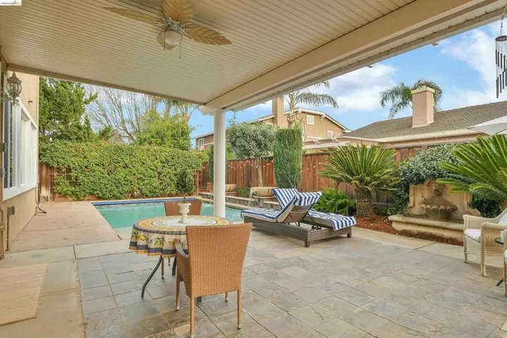 Fenced backyard with a patio area and a ceiling fan