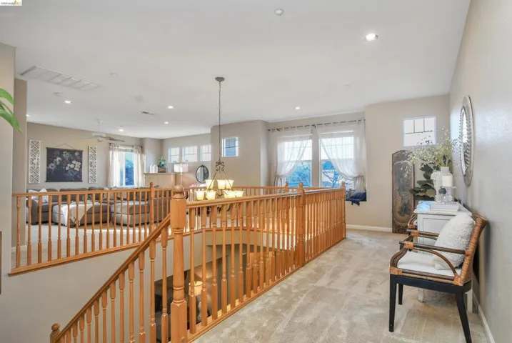 Hall with light carpet, an upstairs landing, and recessed lighting