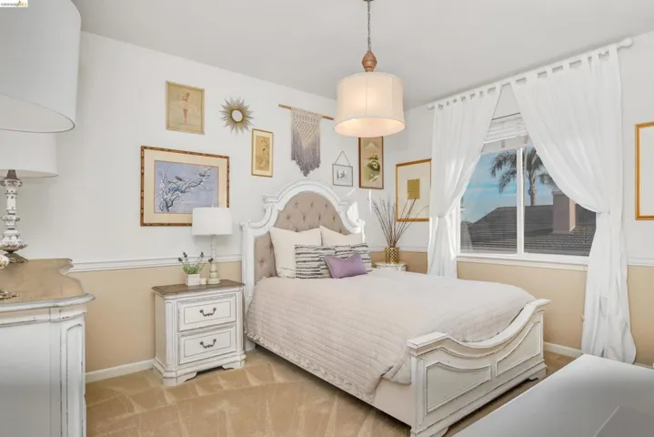 Bedroom with baseboards and light colored carpet