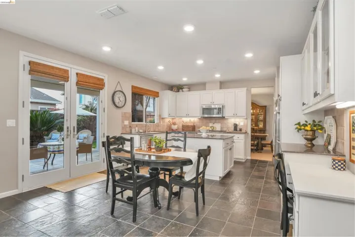 Dining area featuring stone tile flooring, recessed lighting, and french doors