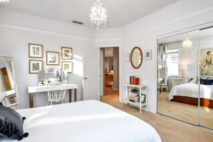 Bedroom featuring a chandelier, light colored carpet, and a closet