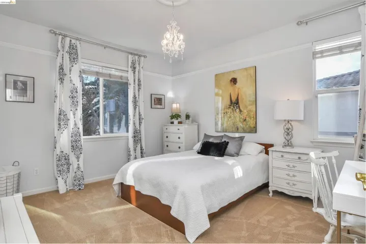 Bedroom featuring light colored carpet and suspended lighting