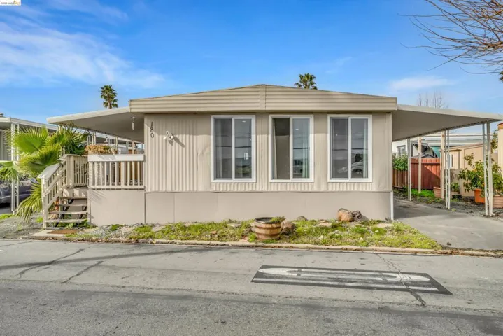 View of side of property featuring an attached carport and concrete driveway