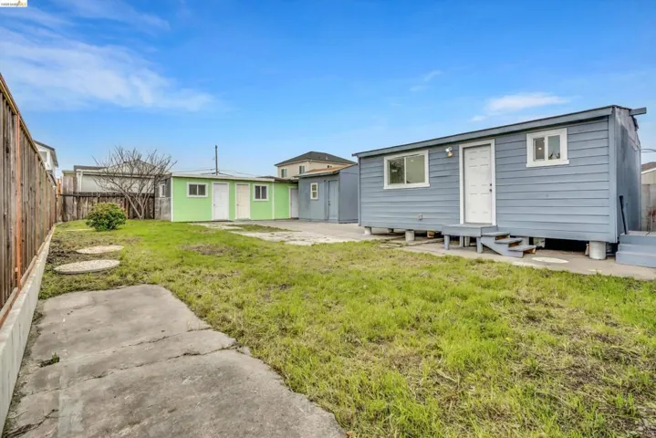 Rear view of house featuring entry steps, a patio area, and a fenced backyard