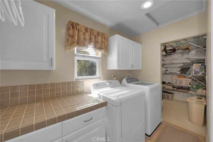 Inside Laundry room with storage room and attic storage