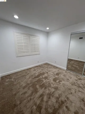 Unfurnished room with light colored carpet and recessed lighting