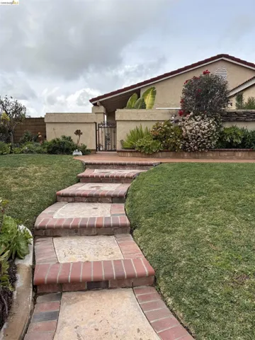 View of front facade featuring stucco siding and a gate