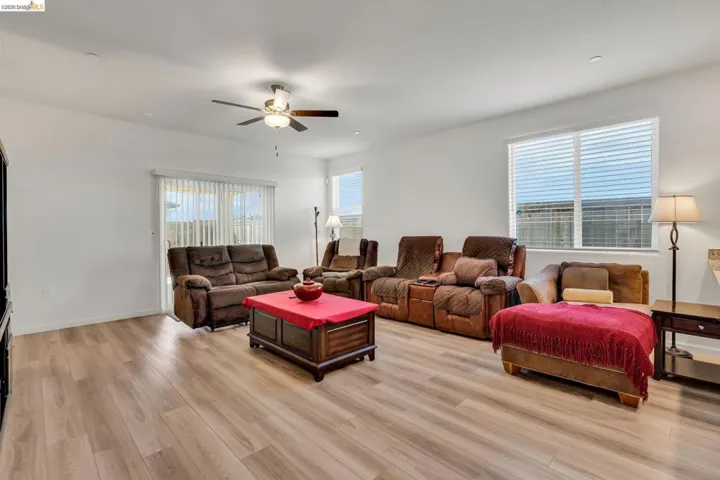 Living room with light wood-type flooring, ceiling fan, and plenty of natural light