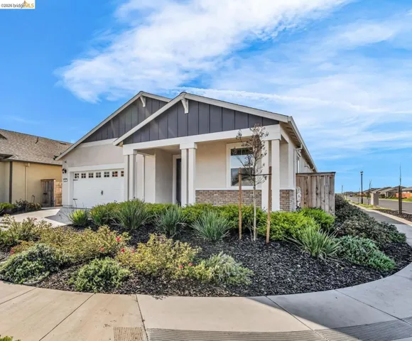View of front of house featuring brick siding, stucco siding, a garage, and concrete driveway