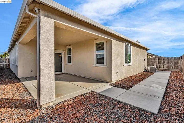 Rear view of property featuring a patio, a fenced backyard, and stucco siding