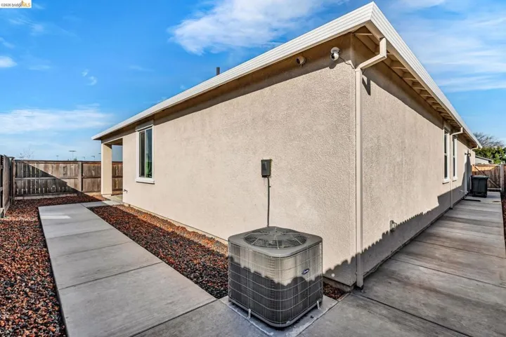 View of side of home featuring a fenced backyard and stucco siding