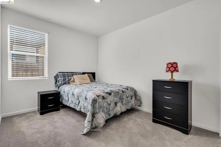 Bedroom with baseboards and light carpet