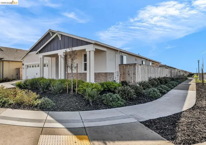 View of property exterior with brick siding, stucco siding, and a garage
