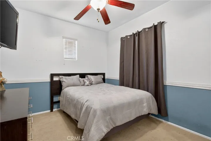 Bedroom #3: Bright and inviting bedroom featuring carpet, crown molding, and an elegant chandelier. Includes a window for natural light.