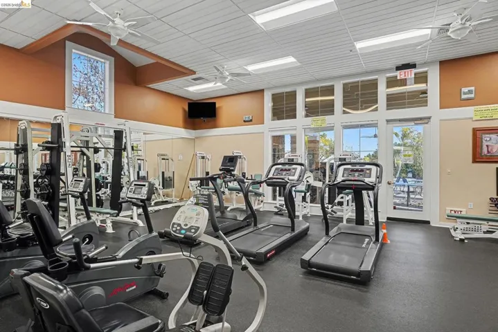 Workout area with a ceiling fan and a high drop ceiling