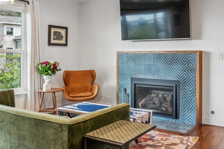 Sitting room featuring a tiled fireplace and wood finished floors